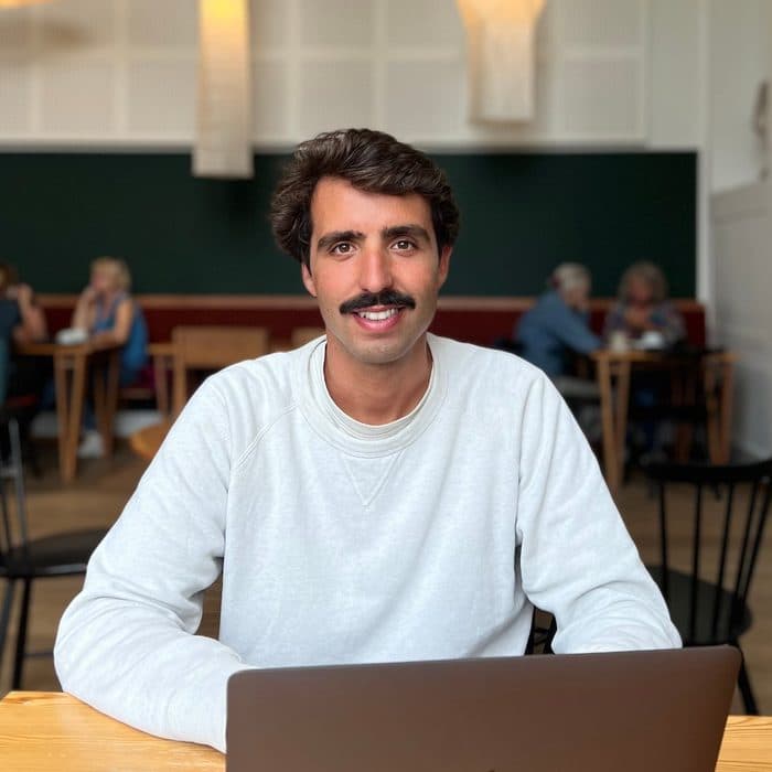 Pierre Guilbaud, souriant, à son ordinateur dans un café